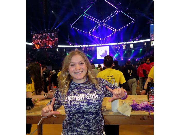 Penn State DuBois student Paige Miller stands on the dance floor of the Bryce Jordan Center during THON 2025 wearing a “Jen’s Warriors” tee shirt in remembrance of her mother, who passed away in 2019 after a battle with cancer.